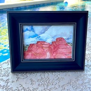 Watercolor by Arizona artist C. Hensley. “Storm Clouds” over red rock.